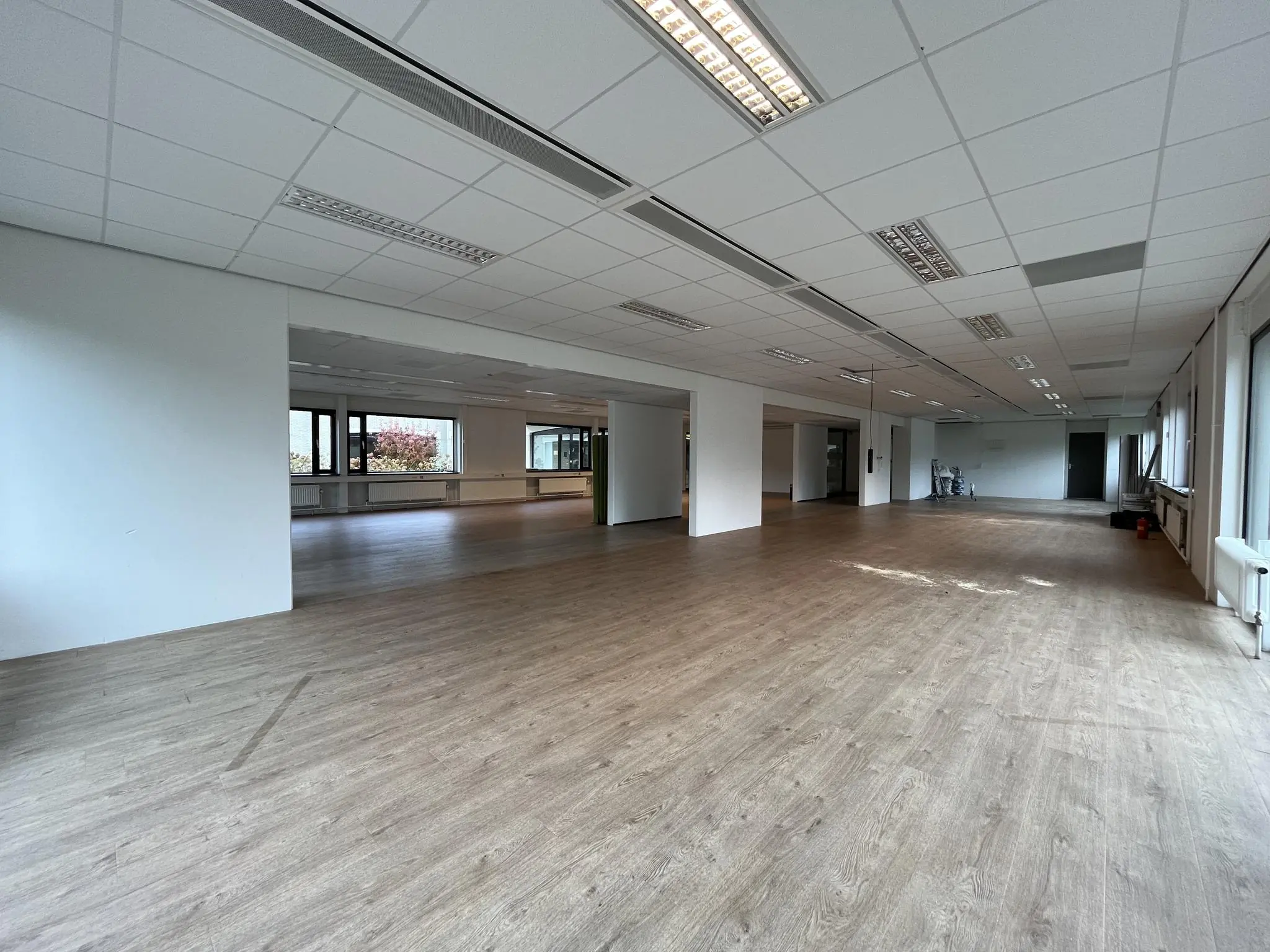 Leegstaand kantoorruimte met houten vloer en systeemplafond aan de Burgemeester Verderlaan.